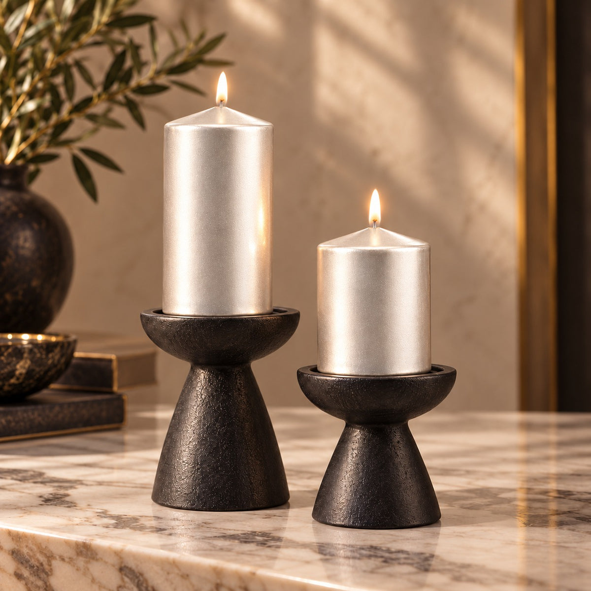 Gümüş sedefli 5x8 ve 5x10 cm silindir mumlar, siyah şamdanlarda mermer yüzey üzerinde