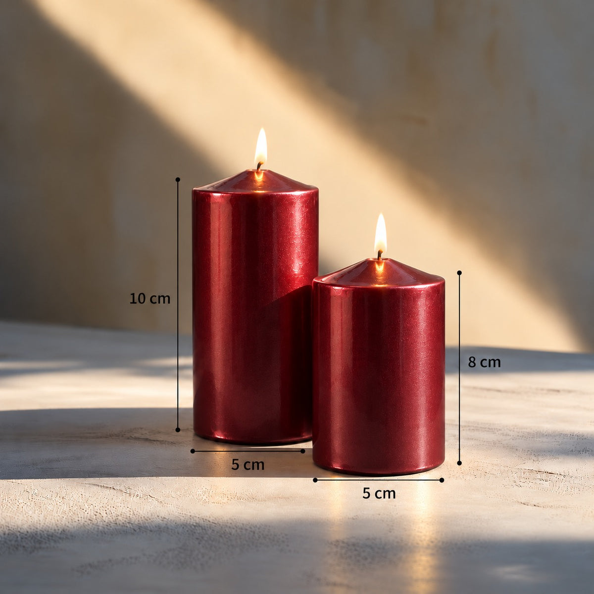 Koyu kırmızı sedefli parlak silindir mum seti, 5x8 cm ve 5x10 cm ölçüleriyle yanan iki mum